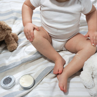 FATSKN grassfed and grassfinished tallow whipped body butter being applied by baby with stuffed animal