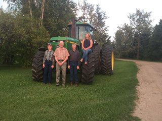 Lucends Ranch family standing together in front of their tractor.