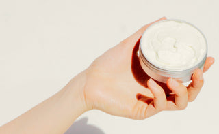 Hand holding whipped tallow body butter.