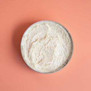 Whipped tallow sugar scrub with orange background.