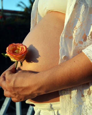 Pregnant woman holding flower.